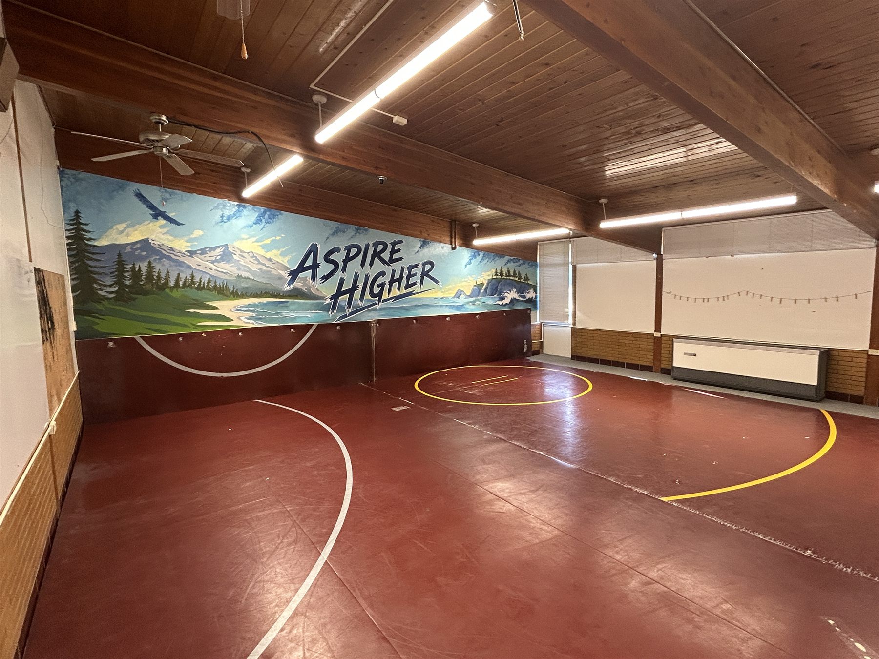 Athletic Room with wrestling mats and an Aspire Higher mural